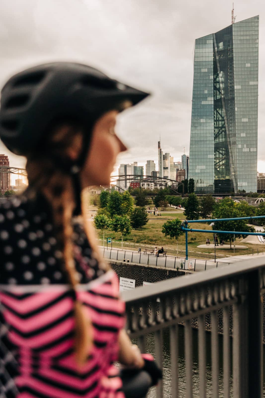 Frau mit Fahrradhelm schaut auf Europäische Zentralbank